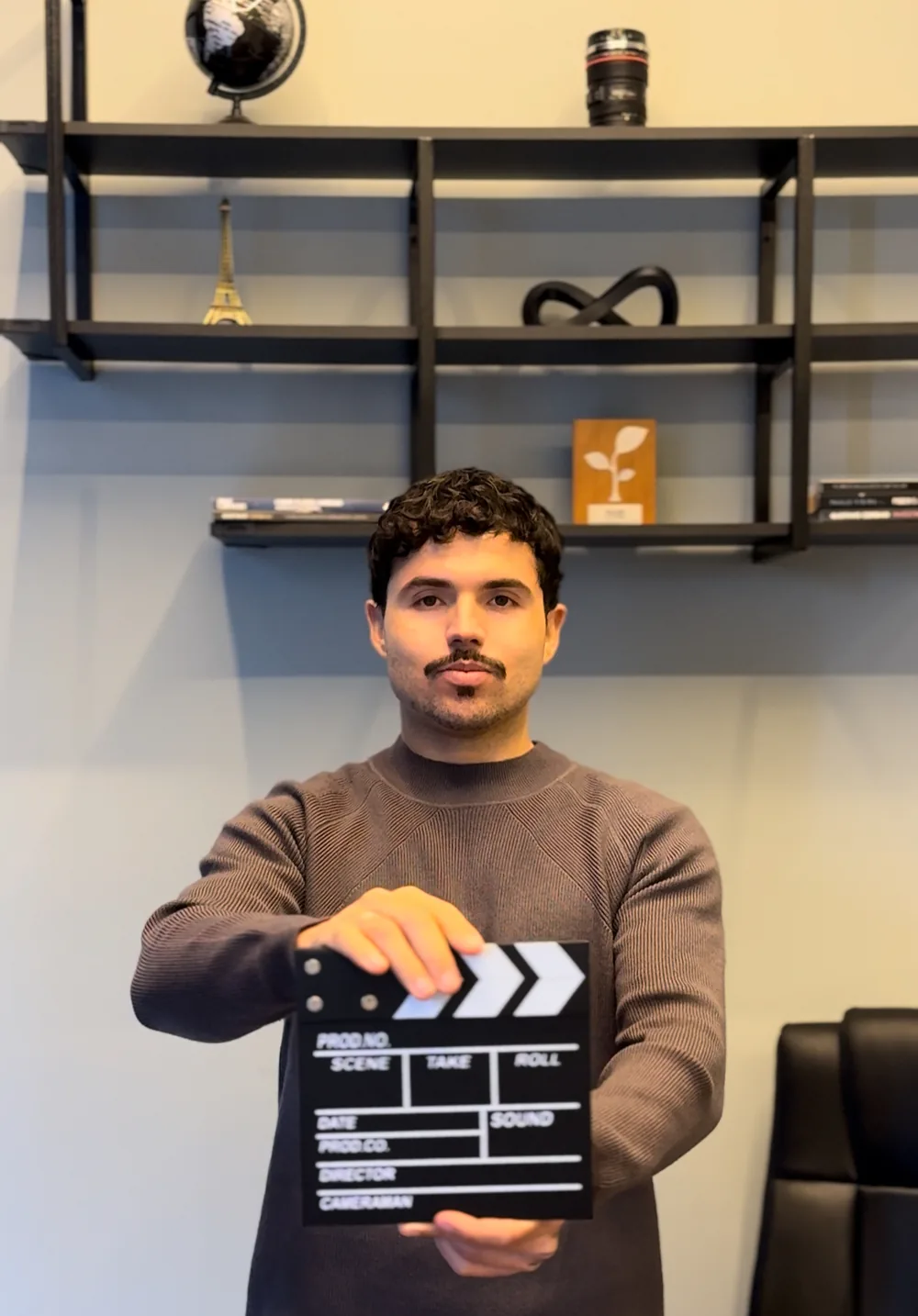 Edu Henrico segurando uma claquete